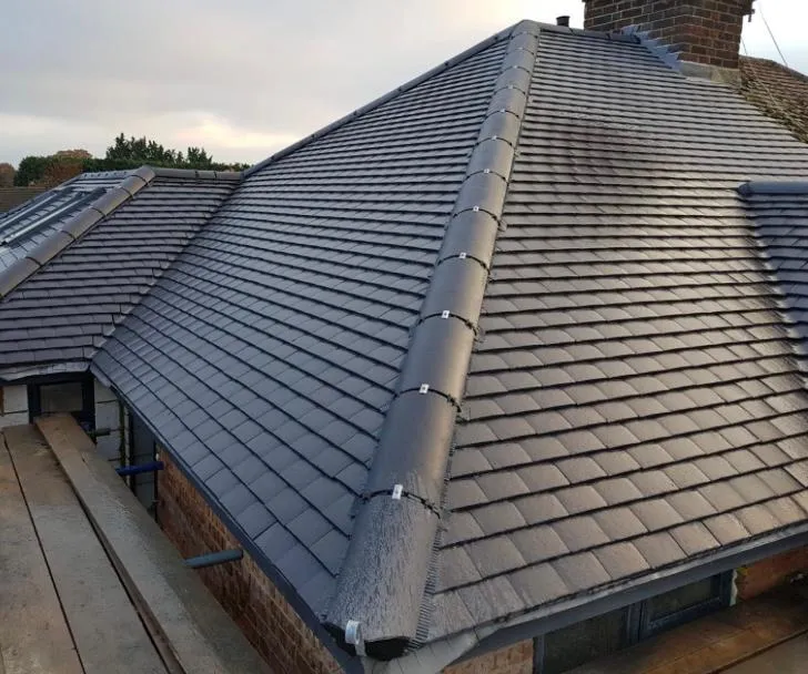 Newly installed grey tiled roof with dry ridge system